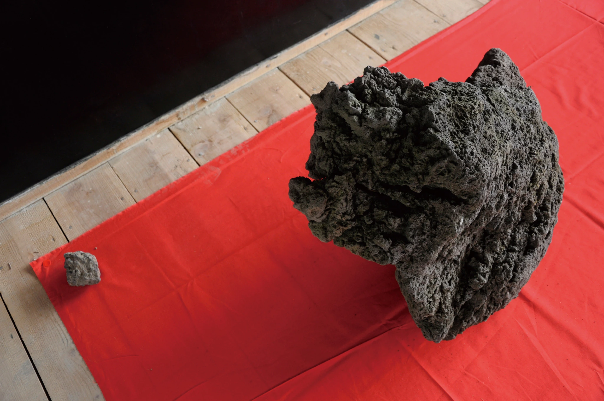 Volcanic rock on red cloth in Domestic Jealousy