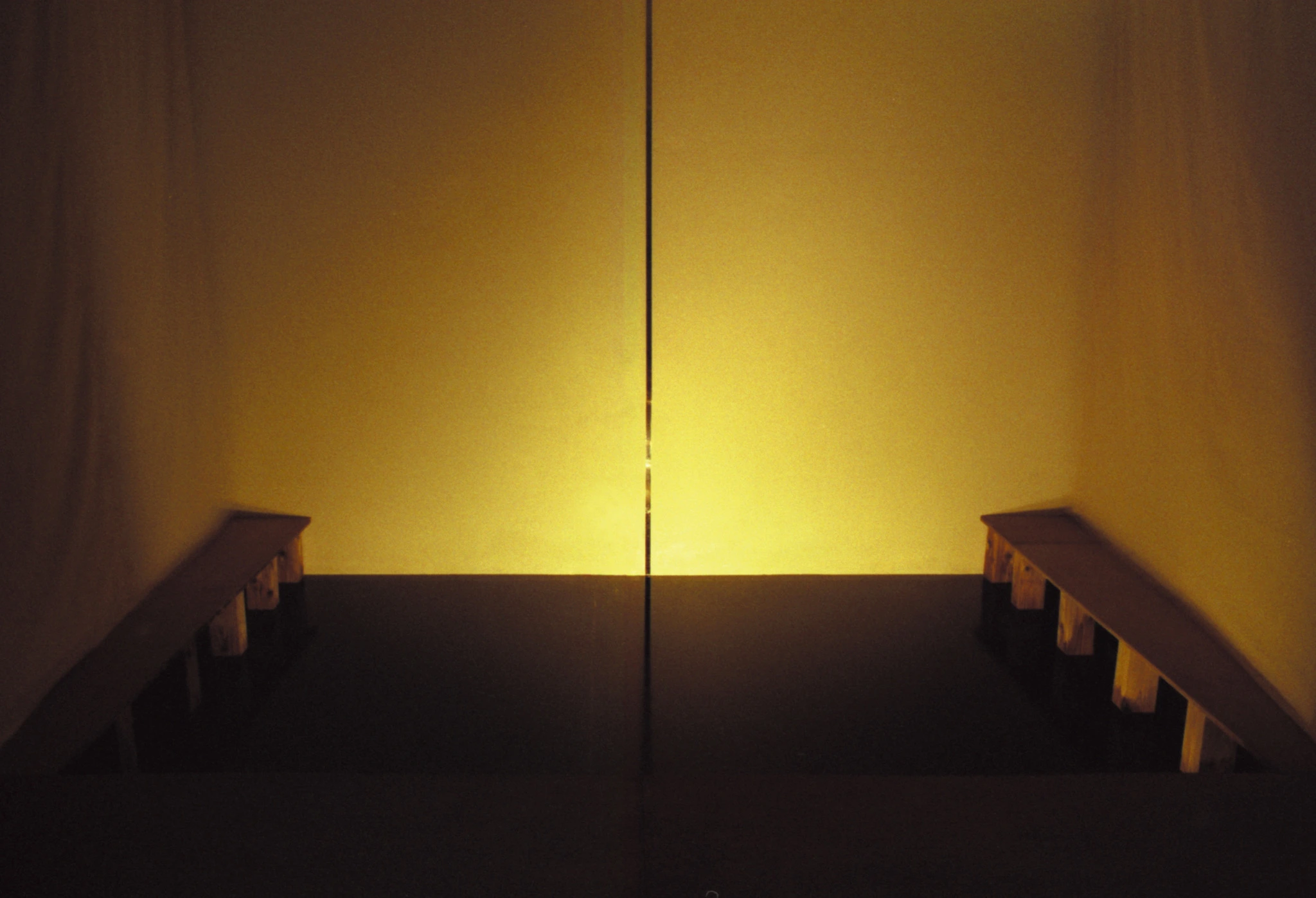 Installation view of EUREKA showing the luminous inner chamber beyond a dark reflective surface