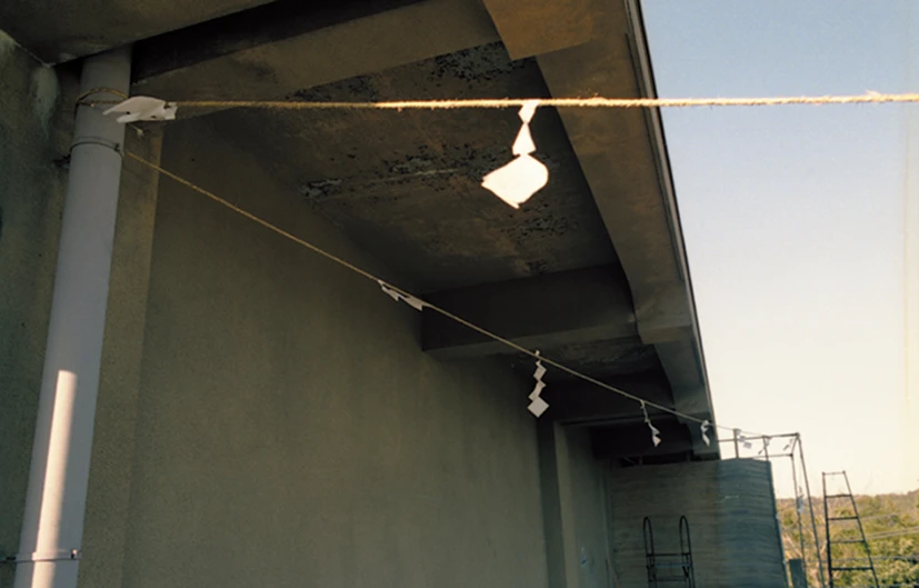 Paper gohei and rope beneath a concrete overhang