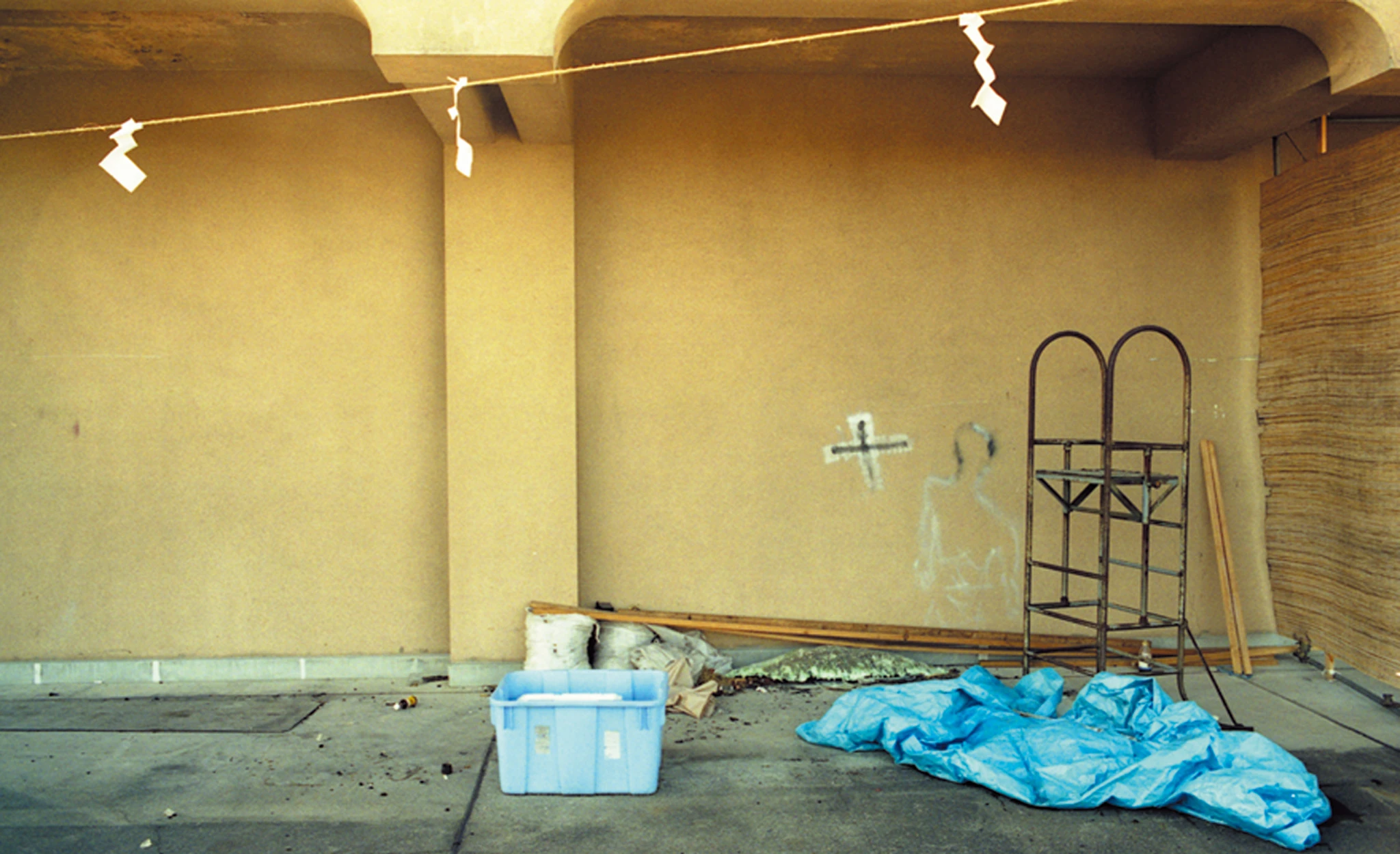 Installation view with work materials beneath the suspended rope