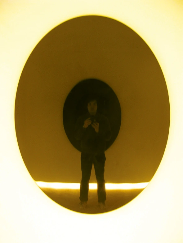 Viewer reflected in the black lacquer mirror surface at Tokyo University of the Arts