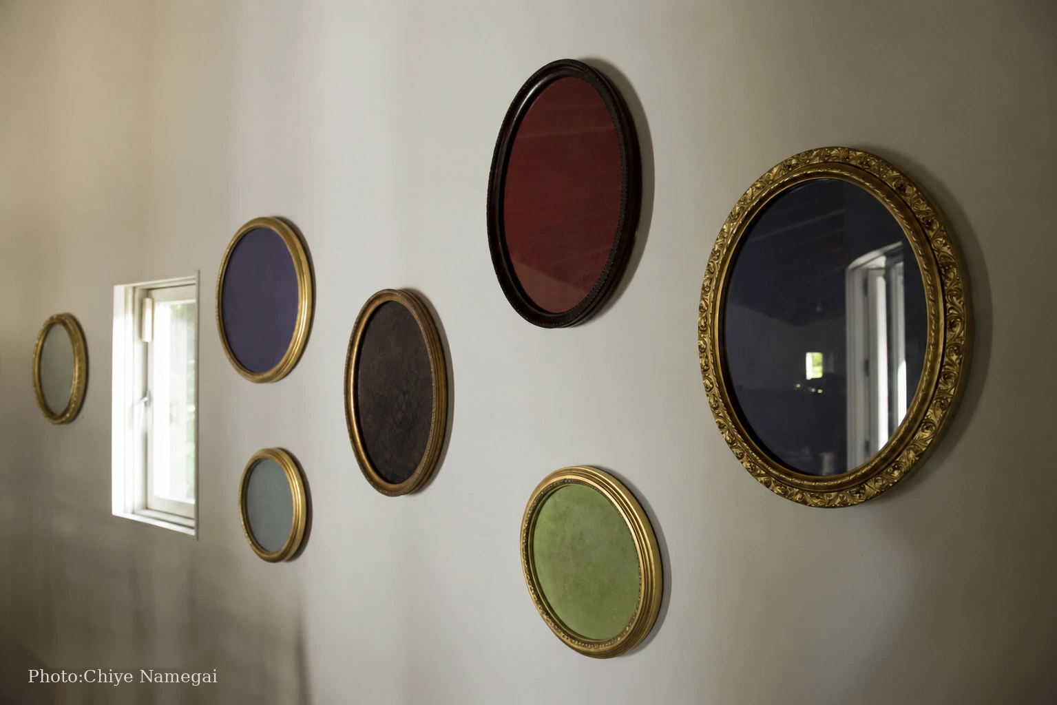Colored mirror works installed along the curved wall
