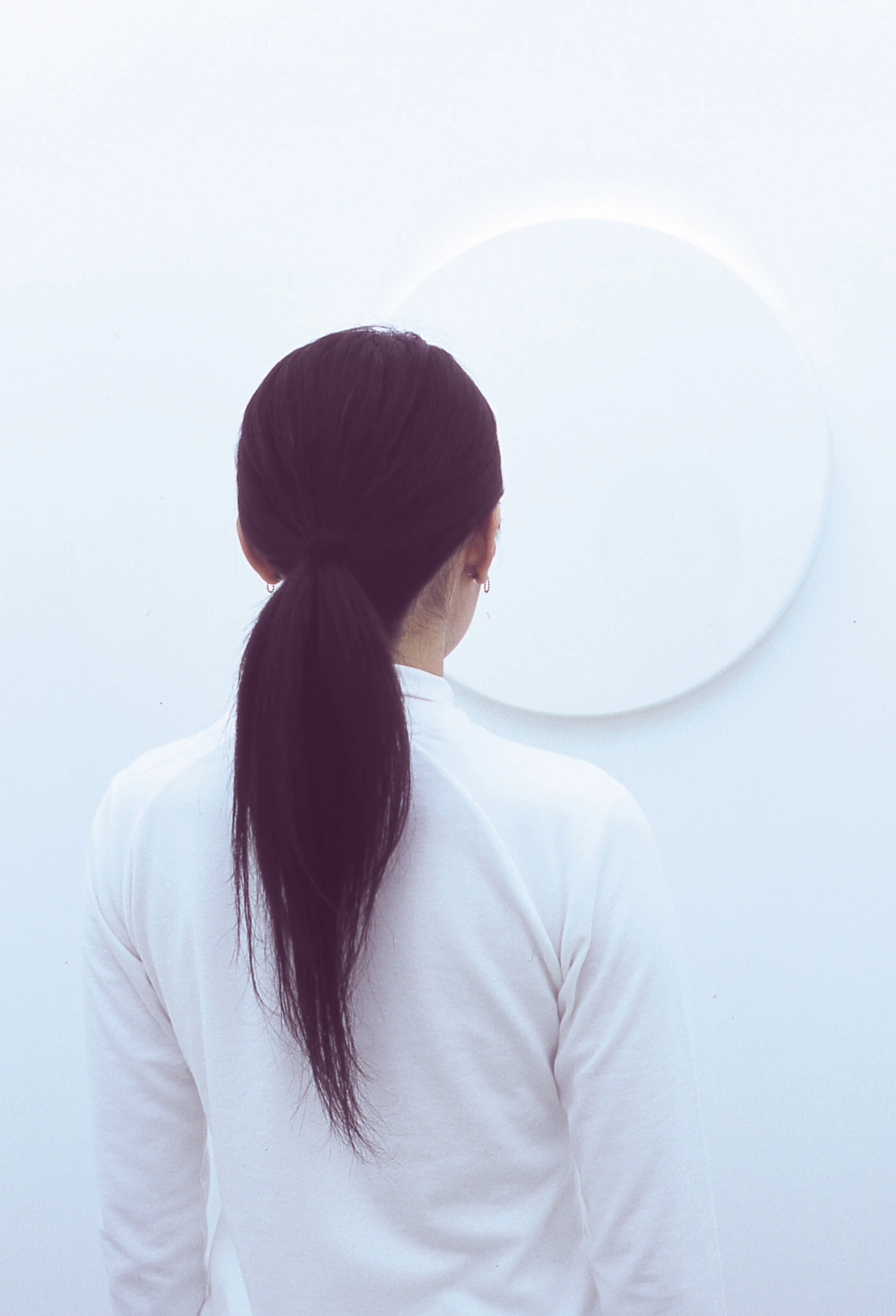 Viewer standing before the white reflective surface in White Room White Mirror, 2005